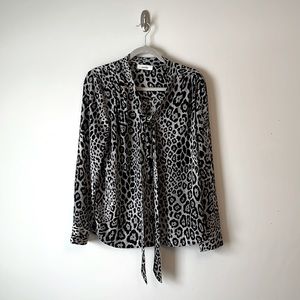 Leopard print blouse with v-neck neckline with built-in tie or bow.